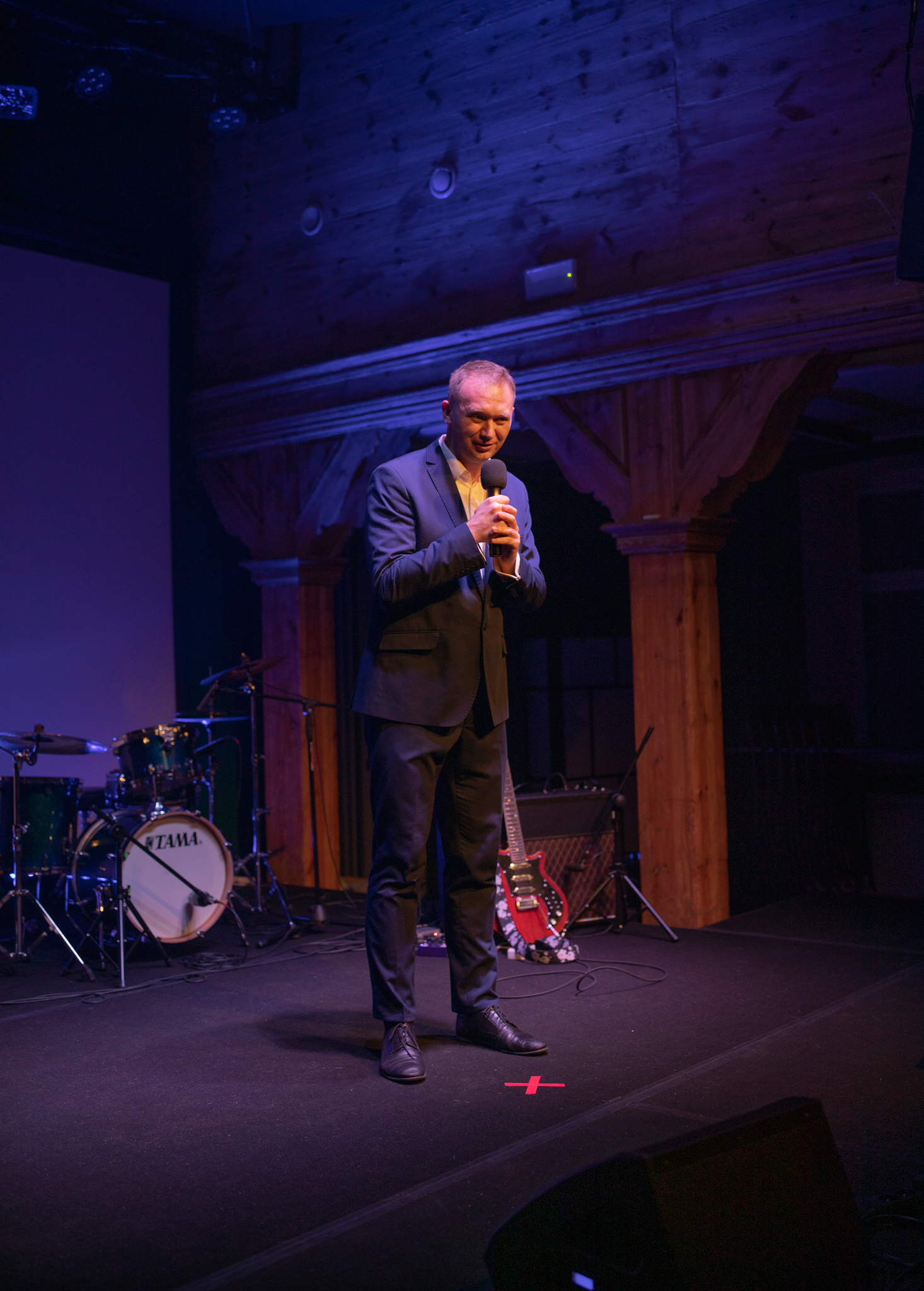 Mateusz Będkowski na scenie z mikrofonem podczas wystąpienia